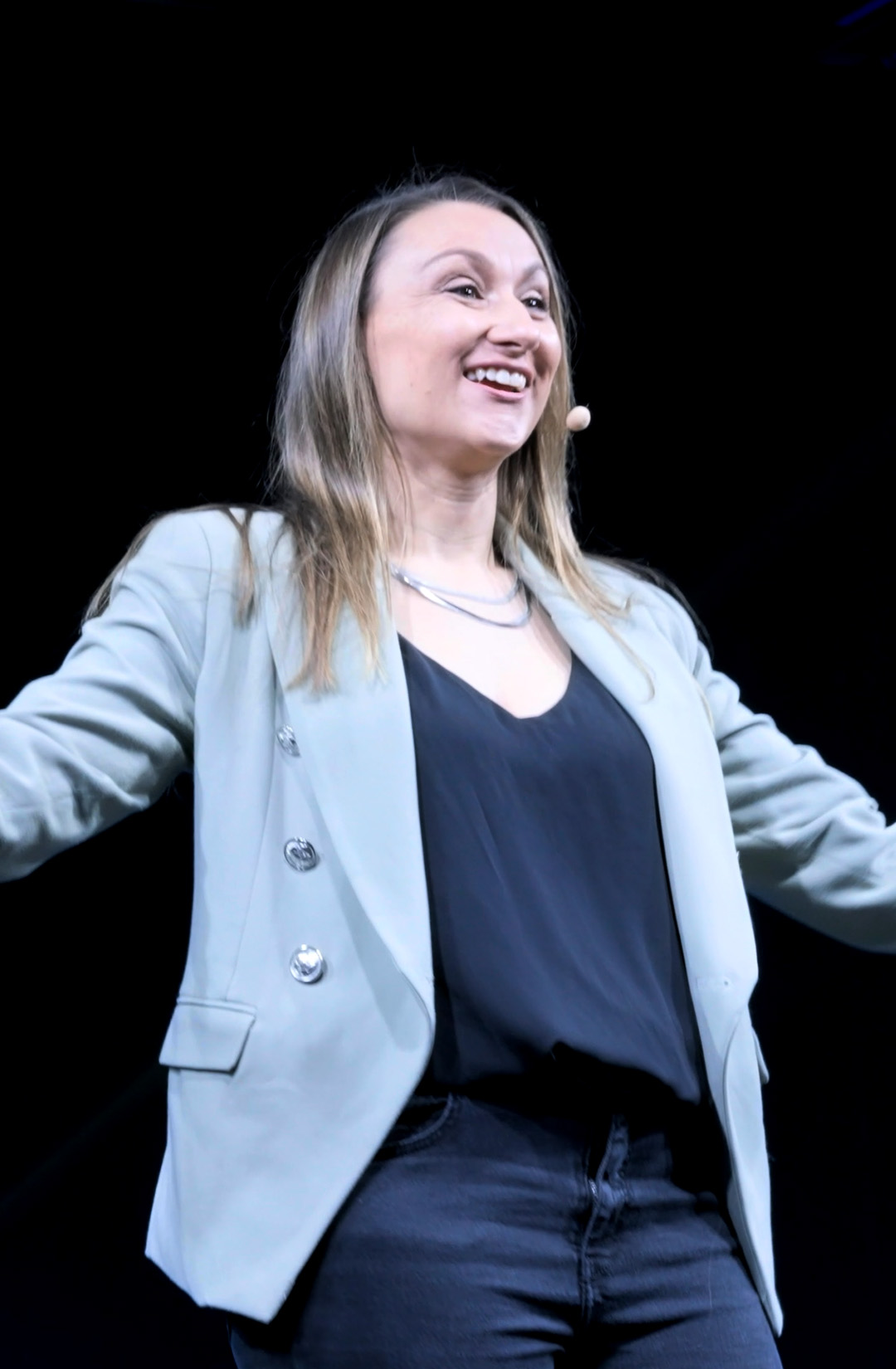Abbie White (also searched as Abbey White or Abby White) against a dark background, with a big smile and arms outstretched mid-motion.